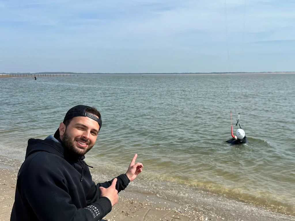 Moniteur de kitesurf aidant un élève débutant lors de ses premiers pas dans l’eau